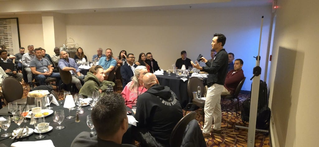 Sam Kwak teaching attendees seated at banquet tables