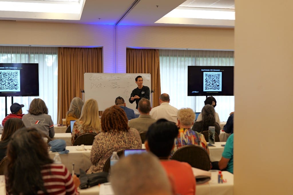 Sam Kwak leading a live whiteboard walkthrough at an in-person seminar